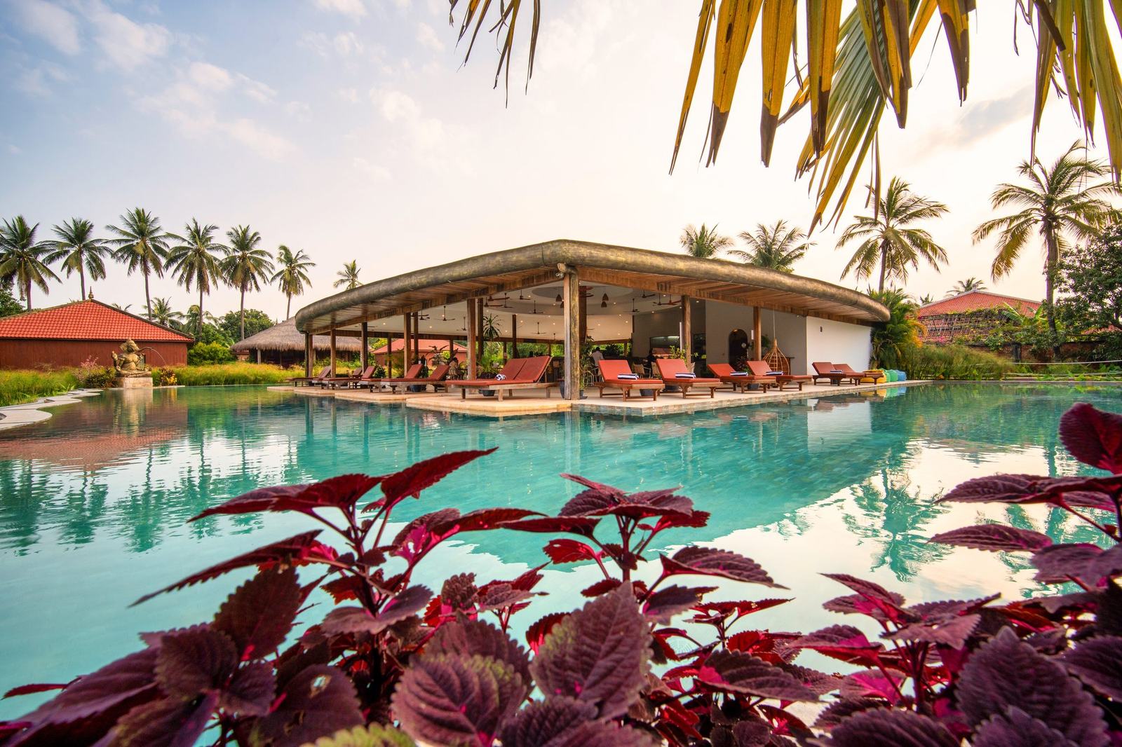 The restaurant pavilion across the big pool, red leaves in the foreground