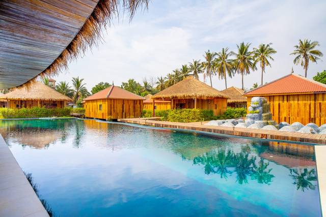 The big pool by day, wooden bungalows along its edge
