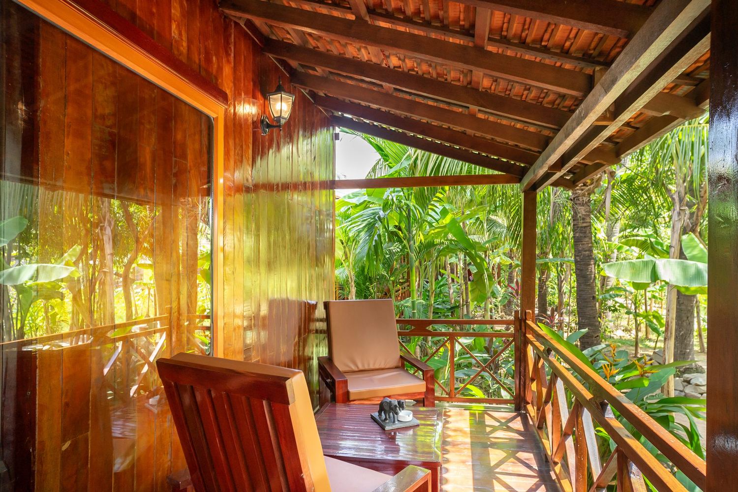 Wooden veranda of a terrace bungalow facing the tropical garden
